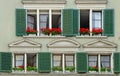 Old house with green shutters and geraniums Royalty Free Stock Photo