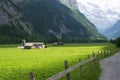 The old house in the middle of Lauterbrunnen valley with a view of wooden fences of walikng road