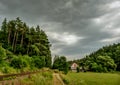 Old house near the forest beside the road and track. Royalty Free Stock Photo