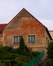 Old house with red bricks walls and peeling plaster