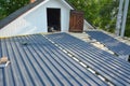 Old house roof repair and renovation with lightweight metal, steel, corrugated, paint coated roofing sheets. Metal roofing
