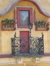 An old house with small window and blooming geraniums.