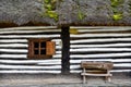 Old house with small wooden window and bench in a vintage romanian village style Royalty Free Stock Photo