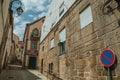 Old house with stone wall on alley and NO PARKING road sign