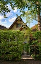 Old house with thatched roof and front yard behind a green hedge Royalty Free Stock Photo
