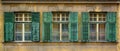 Old house with three windows and green wooden shutters Royalty Free Stock Photo