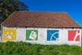 old house with wall with 4 symbols in different colors, green, red, yellow and blue.