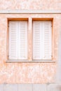 An old house wall and two windows with white wood shutters Royalty Free Stock Photo