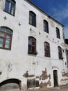 An old house with a white facade and beautifully shaped windows on a sunny summer day in Vyborg
