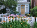 Old house with white picket fence and flowers in front garden Royalty Free Stock Photo