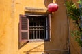 Old house window with shutter, yellow wall and red lantern. Hoi An historical town architecture detail Royalty Free Stock Photo