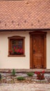 Old house with windows and flowers, wooden doors, plants.