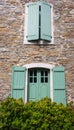 Old house with windows and green shutters. Traditional exterior of rural house, France. Facade of medieval stone building. Royalty Free Stock Photo