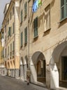 old houses with covered walkway in narrow street at street market time, Chiavari , Italy