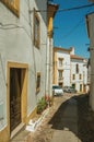 Old houses with whitewashed wall in alley on slope