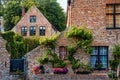 Old housesof Begijnhof Beguinage with flowers in Bruges, Belgium