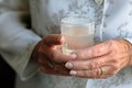 Old human hands close up grandmother holding glass of mineral water woman drinking fresh clear health pure refreshing Royalty Free Stock Photo