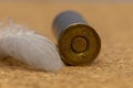 Old hunting cartridges are scattered on a textured background, there is a bird`s feather, close-up, selective focus. Concept: bird Royalty Free Stock Photo