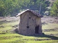 An old hut in the middle of a meadow made of stone and thatch Royalty Free Stock Photo