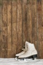 Old ice skates against an weathered wooden wall Royalty Free Stock Photo