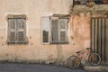 Old idyllic house with orange bike in front of it in a city in the Provence in France