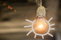 Old incandescent lamp with painted rays in the dust and cobweb on a brown background