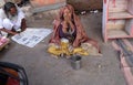 Old Indian beggar waits for alms on a street in Pushkar, India