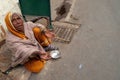 Old Indian beggar waits for alms on a street in Pushkar, India