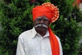 Old Indian grandfather wearing orange color turban and giving pose for photo