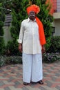 Old Indian grandfather wearing orange color turban and giving pose for photo