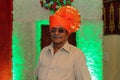 Old Indian grandfather wearing orange color turban and giving pose for photo