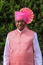 Old Indian grandfather wearing pink color turban and giving pose for photo