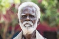 Old indian poor man with a dark brown wrinkled face and white hair and a white beard, serious or sad Royalty Free Stock Photo