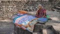 An old Indian woman sits with her washed godhadis (upcycled quilts) on the banks of the river.