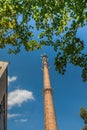 Old industrial chimney made of brick without smoke, with antennas, against the blue sky Royalty Free Stock Photo