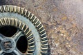 Old industrial gear wheel against rusty metal background