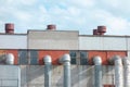Old industry plant with pipes and tubes. Outside view of manufacturing complex under blue cloud sky. Concrete walls, metal frames Royalty Free Stock Photo