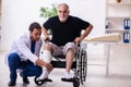 Old injured man visiting young male doctor traumatologist