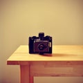 Old instant camera on a table, with a retro effect