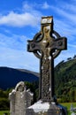Old Ireland celtic stone cross in cemetery at blue sky