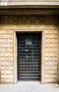 Old iron black door locked with ancient details. Aged closed front door at baroque architectural style building with metallic