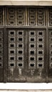 Old iron black door locked with ancient details. Aged closed front door at baroque architectural style building with metallic