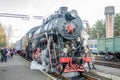 Old iron black retro vintage Soviet steam locomotive with red star arrives at the railway station to board passengers Royalty Free Stock Photo