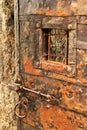 Old iron-clad door with grilled window, bar lock and ring handle