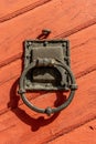 Old iron door knocker on a red wooden door Royalty Free Stock Photo