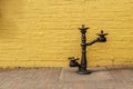 Old iron drinking water fountain with yellow rustic stone wall. Royalty Free Stock Photo