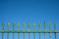 Old iron fence on blue sky - vintage wrought metal spikes -