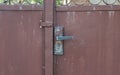 Old iron fence. Old cracked paint. Vintage fence. Rusty metal. Rust structure. Old vintage door handle. Padlock. Iron gate. Royalty Free Stock Photo