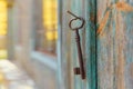 An old iron retro key hanging on a nail against the wall of a rustic wooden house, the concept of a secret, inheritance, Royalty Free Stock Photo