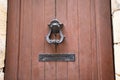 Old iron ring black knocker on vintage wooden retro brown door for knocking on facade classical europe house Royalty Free Stock Photo